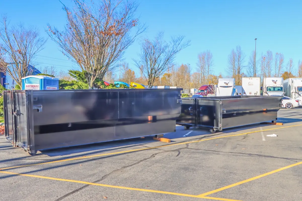 Professional dumpster rental service with roll-off container on residential driveway in Magna